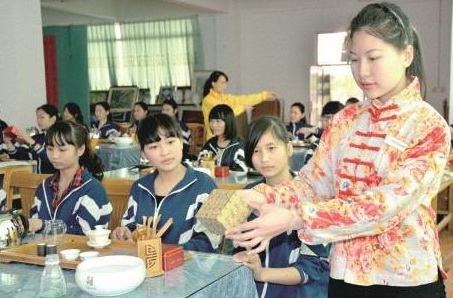 茶艺师正在给英德市职业技术学校茶艺兴趣班学生演示茶艺的标准动作。